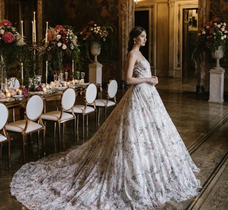 Bride in a long patterned train in front of a dressed banquet table, Samantha Pretto