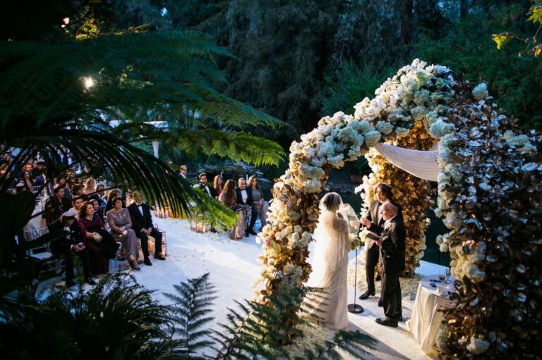 Floral chuppah arch and seated guests at an evening garden ceremony, Samuel Lippke Studios