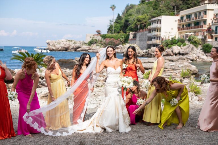Bride and bridesmaids in bright dresses on a seaside terrace, Samuel Lippke Studios