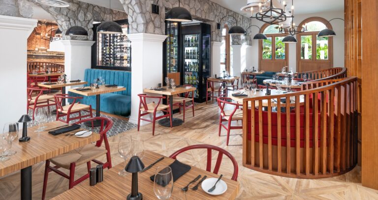 A restaurant with stone walls, booth seating and a wine display, Sandals Dunn's River