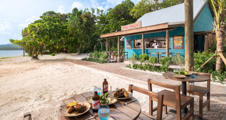 A beachside grill shack with plates of food and beer on the table, Sandals Dunn's River