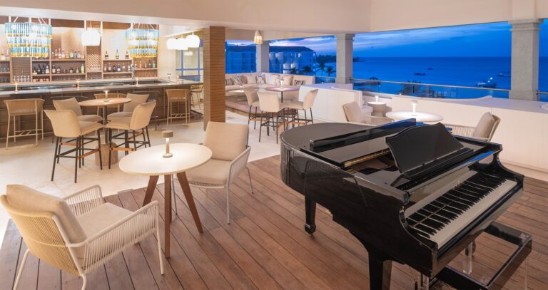 A bar lounge with a grand piano and an evening sea view, Sandals Dunn's River