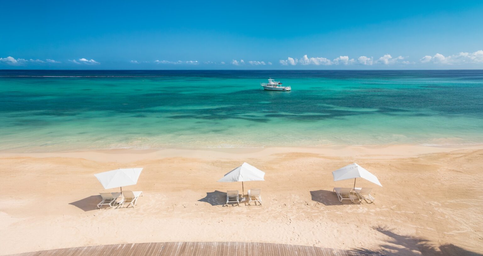 The beach in front of the resort, with parasols and loungers on pale sand