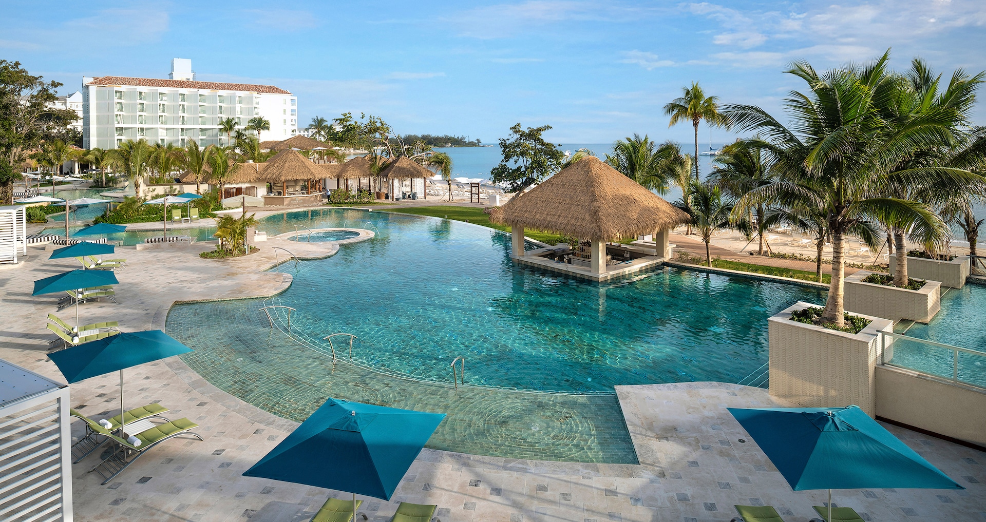 The curving pool with a thatched pavilion and the beach beyond, Sandals Dunn's River