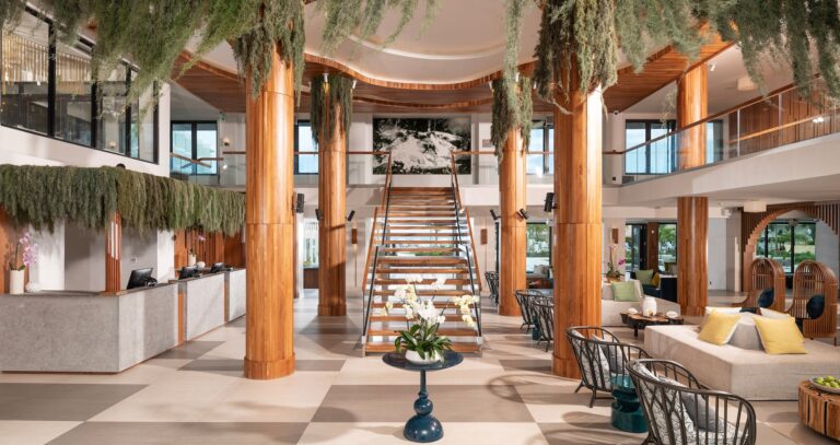 The lobby with timber columns, hanging plants and a central staircase, Sandals Dunn's River