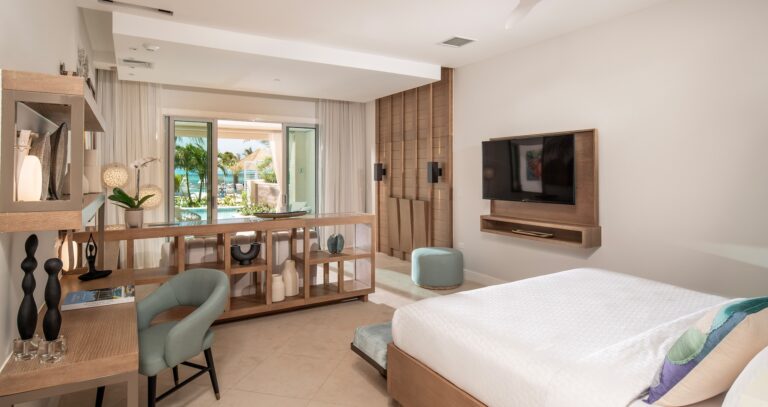 A suite bedroom with a sitting area and view to the pool, Sandals Dunn's River