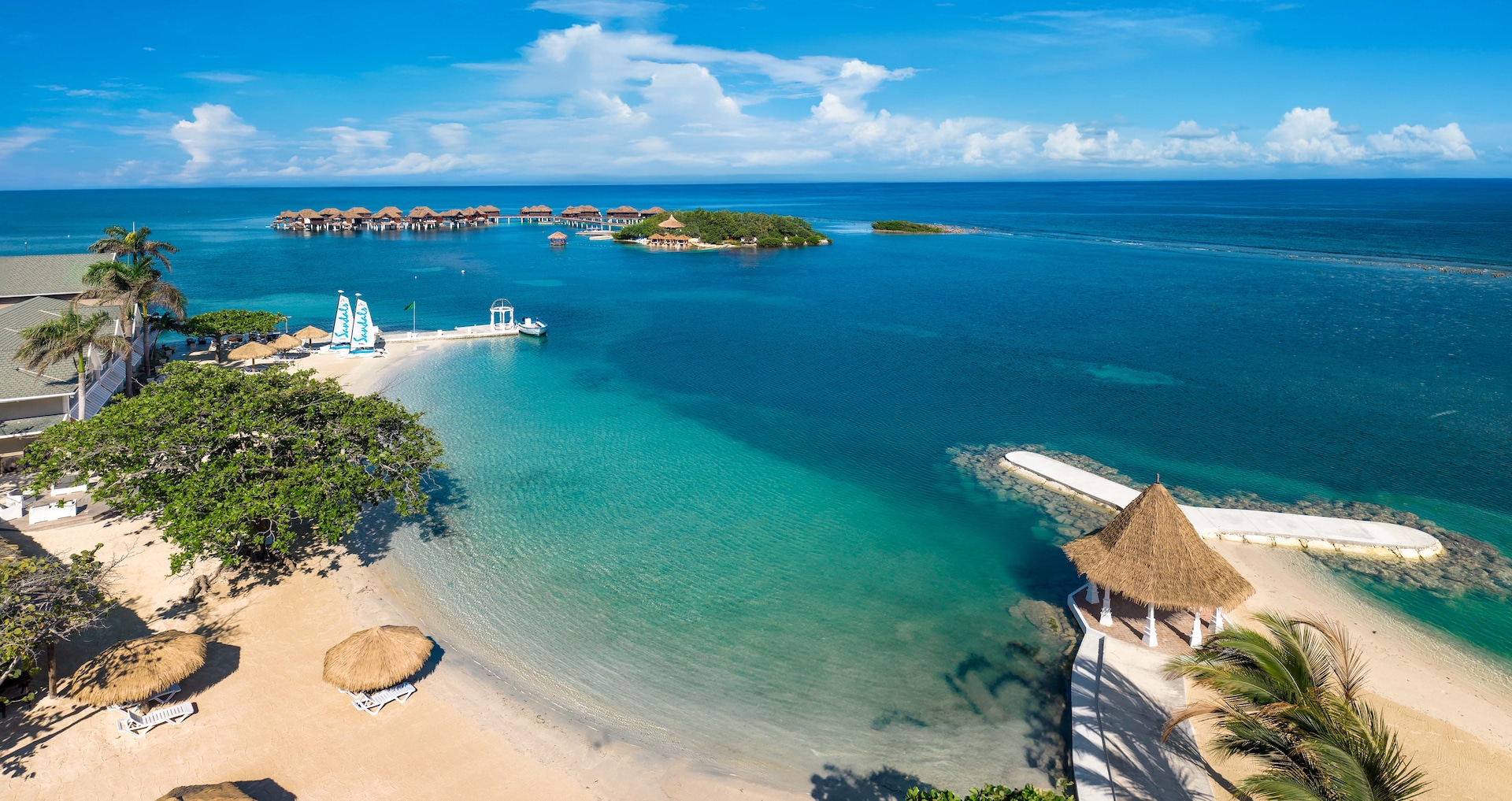 Aerial view of the beach and the private offshore island with its overwater bungalows beyond, Sandals Royal Caribbean Resort and Private Island