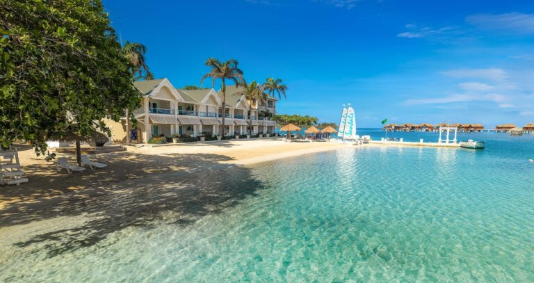 A white colonial beach building with the island beyond, Sandals Royal Caribbean Resort and Private Island