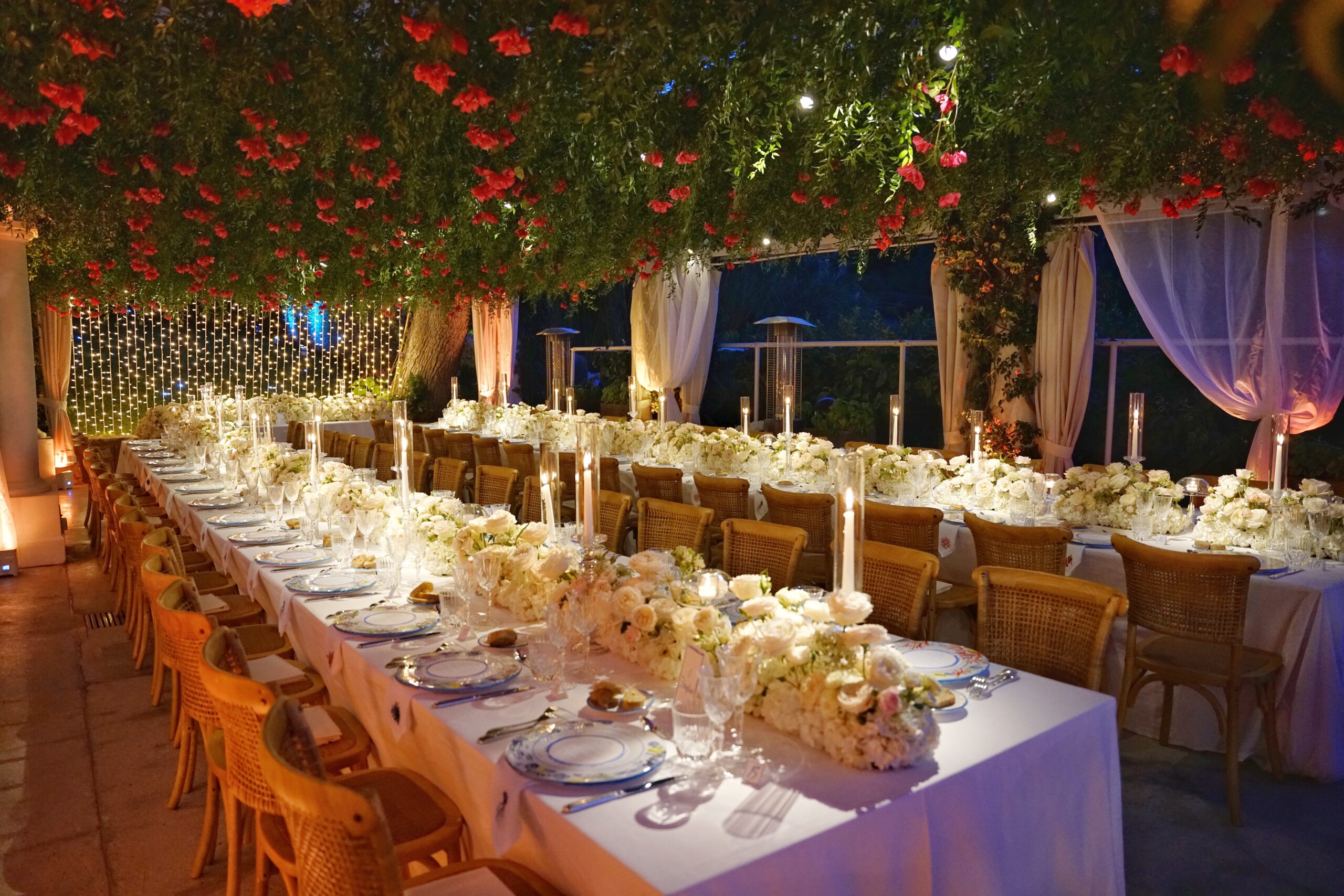 Long tables laid for dinner under a canopy of red flowers, a wedding on Capri, Sara D'Angelo