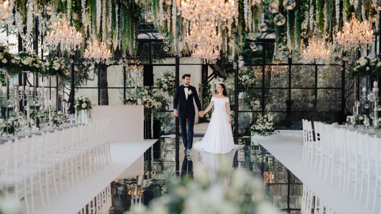 Couple walking the mirrored aisle between long tables, Sarah Linow