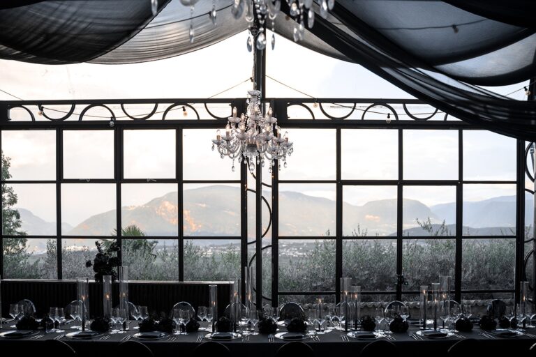 Black and white styled glasshouse tablescape with chandelier and mountain views, Sarah Linow