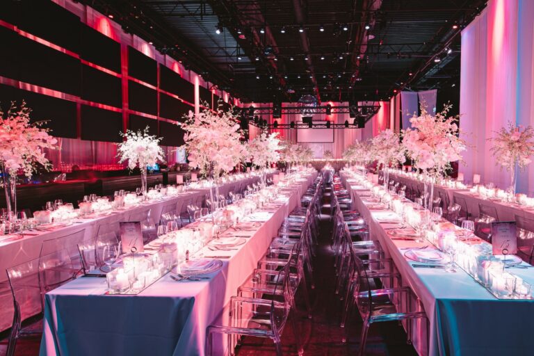 Pink-lit reception hall with long tables, Berlin, Sarah Linow