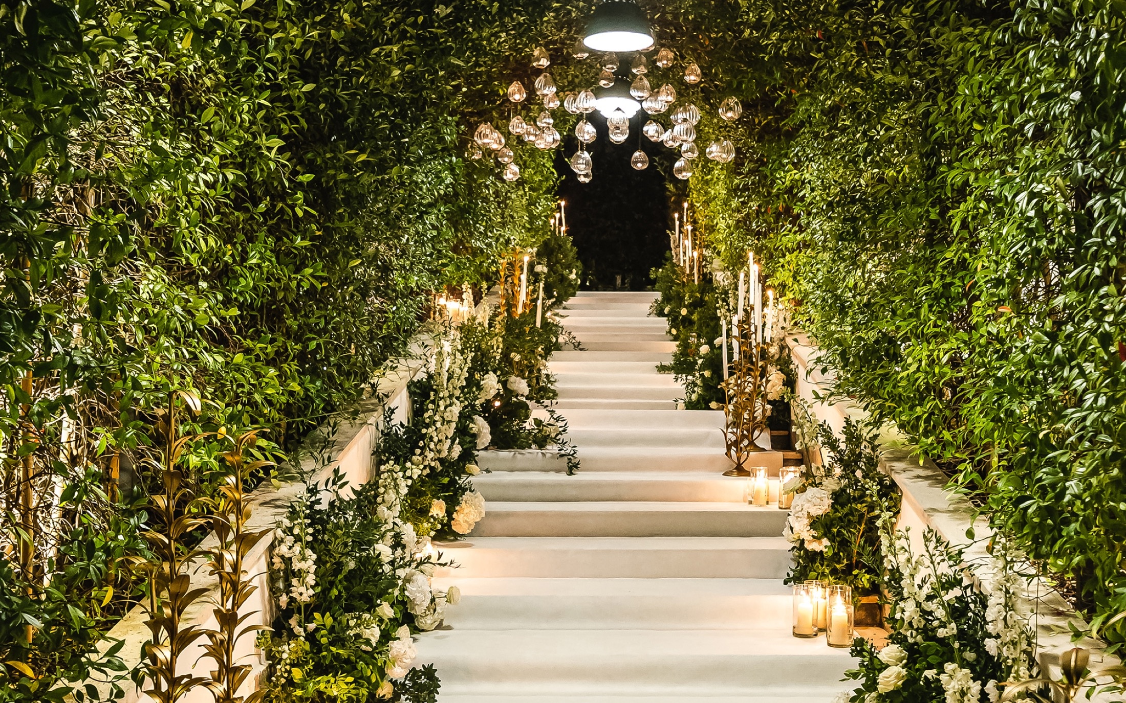 A flower-lined ceremony walk into the gardens, Savoy Hotel & Spa