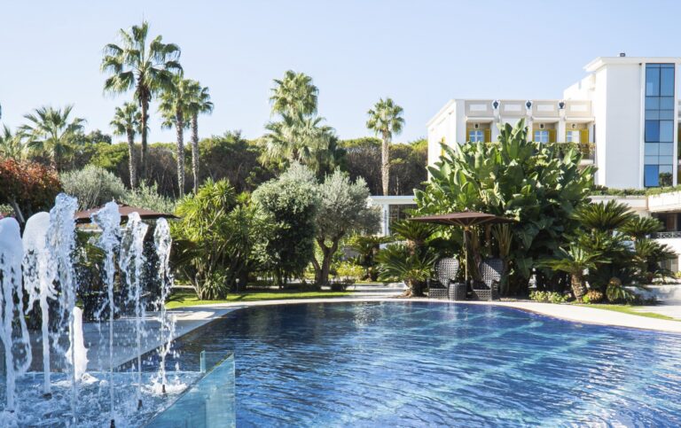 The pool and fountains, framed by palms, Savoy Hotel & Spa