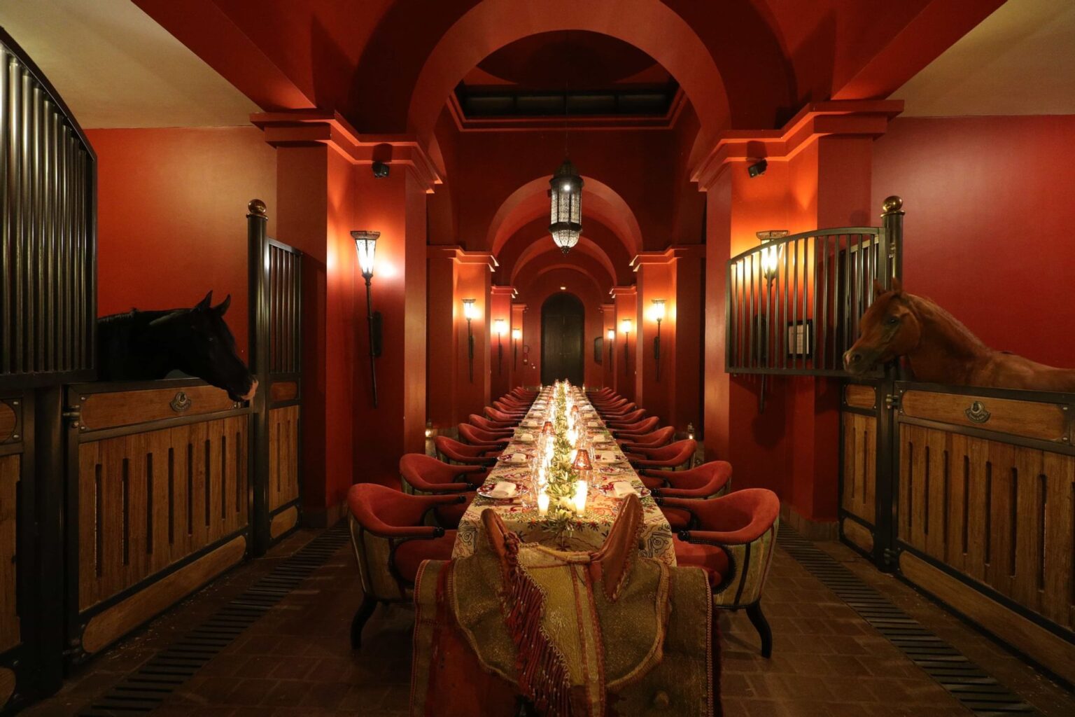 A dinner table laid between the horse stalls