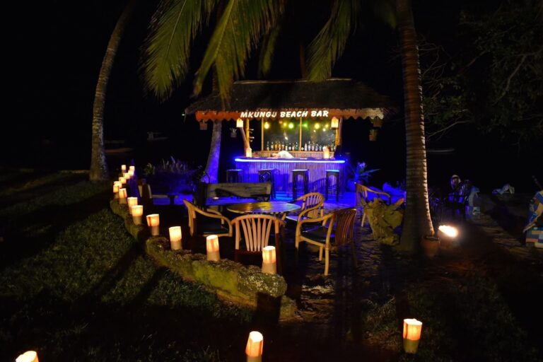 Mkungu Beach Bar lit at night under its makuti roof, Serena Beach Resort & Spa
