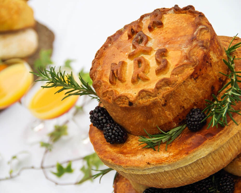 A tiered pork pie wedding cake marked Mr and Mrs
