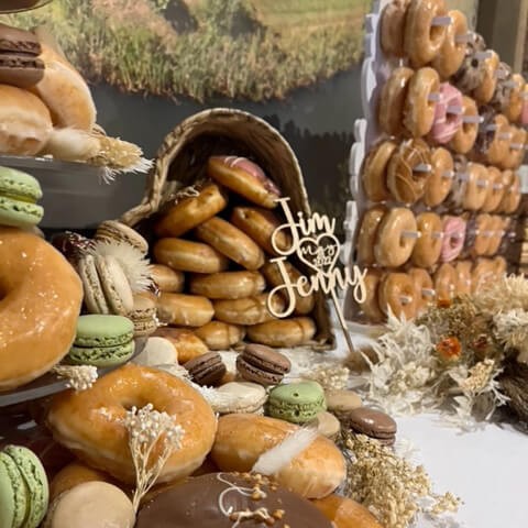 A doughnut and bagel display with macarons and dried flowers
