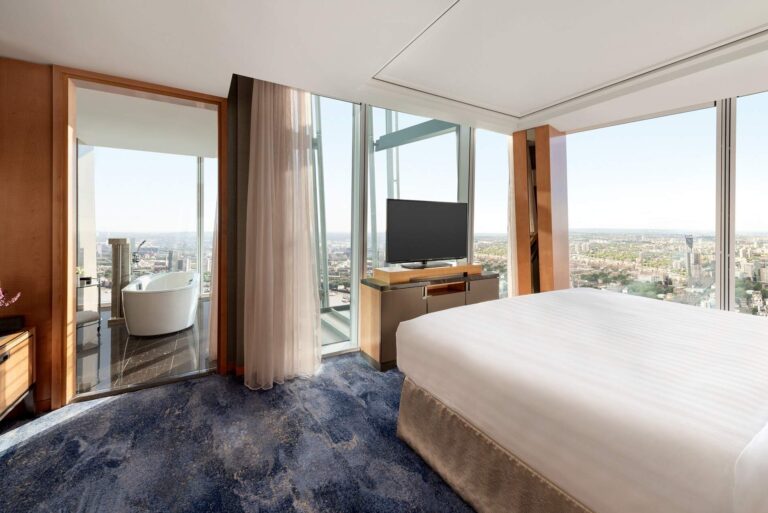 The Iconic Shard Suite bedroom, with a freestanding bath visible beside the window, Shangri-La Hotel, The Shard, London