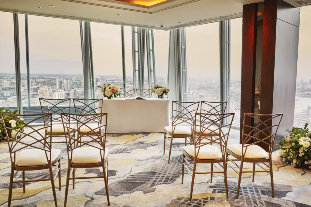 A small ceremony set-up with gold chairs and a dressed registrar table in a corner room over the river, Shangri-La Hotel, The Shard, London