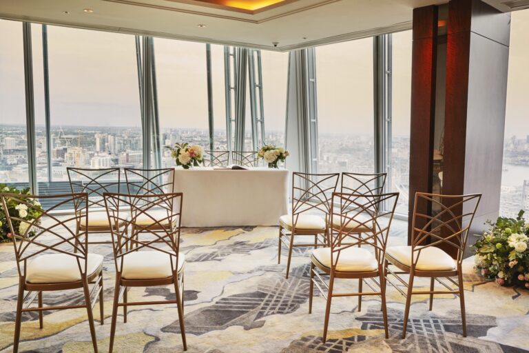A small ceremony set-up with gold chairs and a dressed registrar table in a corner room over the river, Shangri-La Hotel, The Shard, London