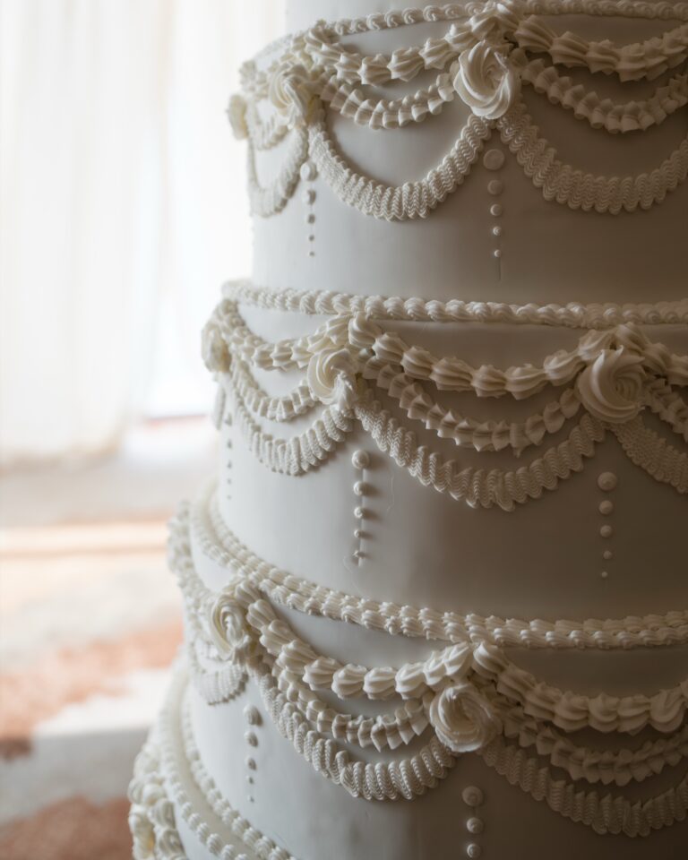 Detail of a tiered white wedding cake piped with lace-like swags, Shangri-La Hotel, The Shard, London