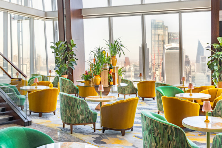 The Sky Lounge, with green and mustard armchairs, plants and the City towers beyond, Shangri-La Hotel, The Shard, London