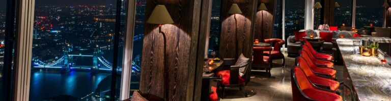 GONG, the cocktail bar on level 52, at night with red leather seats and the lit city beyond, Shangri-La Hotel, The Shard, London