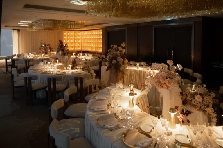 An evening reception lit by table lamps and candles, with tall pale floral arrangements, Shangri-La Hotel, The Shard, London