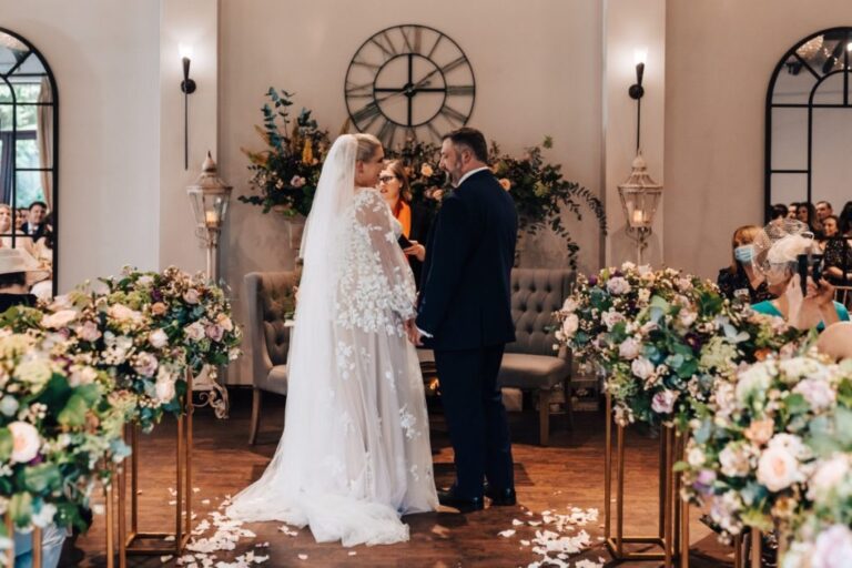 The couple exchange vows beneath a floral pedestal-lined aisle, Shilpa Reddy