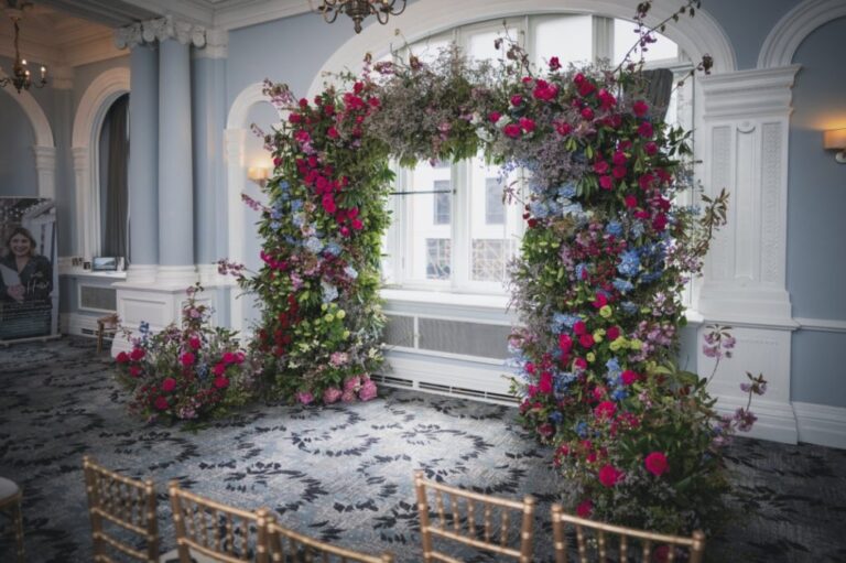 A ceremony arch in jewel-toned rose, hydrangea and delphinium, Shilpa Reddy