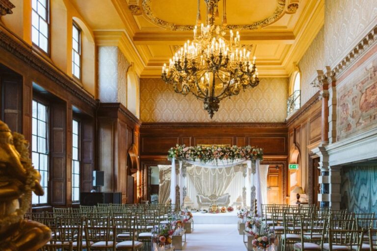 A floral-topped canopy crowns the ceremony beneath a grand chandelier, Shilpa Reddy