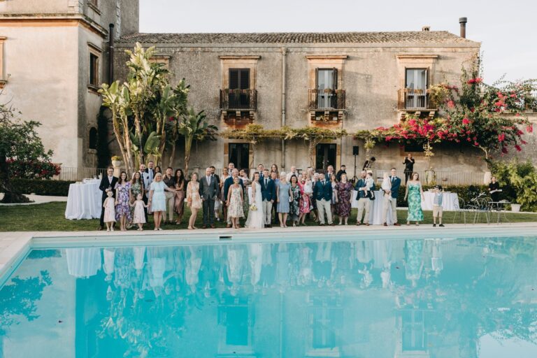 The whole party assembled across the pool in front of the borgo, Sicilian Wedding Day
