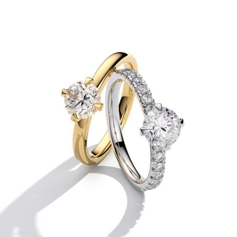 A diamond solitaire engagement ring in yellow gold beside a pave-set band in white gold, Sif Jakobs
