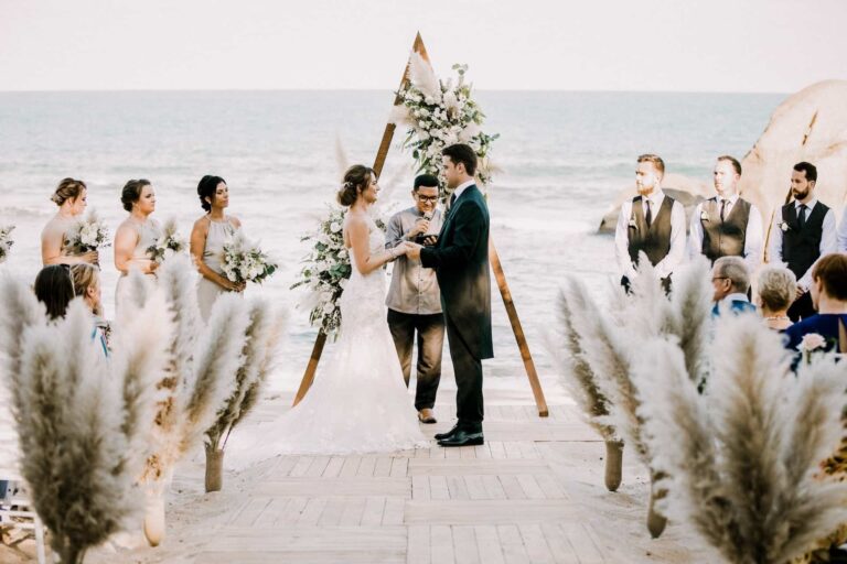 Beach ceremony with a triangular floral arch and pampas grass along the aisle, Silavadee Pool Spa Resort