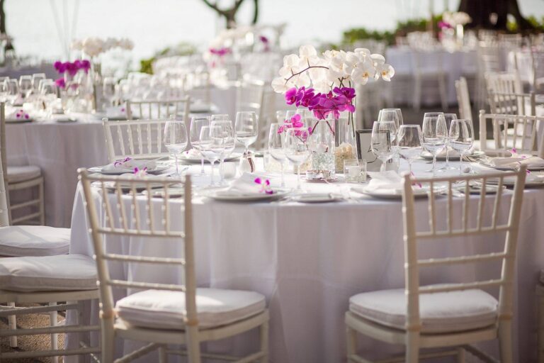 Round reception tables laid with white linen and orchid centrepieces, Silavadee Pool Spa Resort