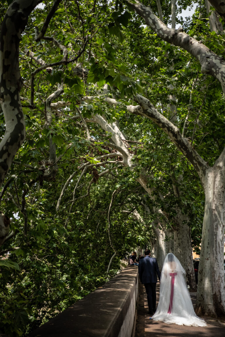 Bride and groom walking under plane trees on a spring wedding day in Rome, Silvia Cleri Photography
