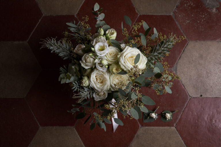 A bouquet of white roses and eucalyptus on a terracotta floor at Tenuta Pantano Borghese, Silvia Cleri Photography