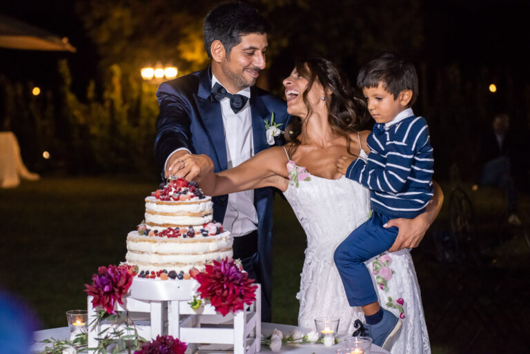 Cutting the cake with a young boy in their arms at Scuderie Cicognani, Silvia Cleri Photography