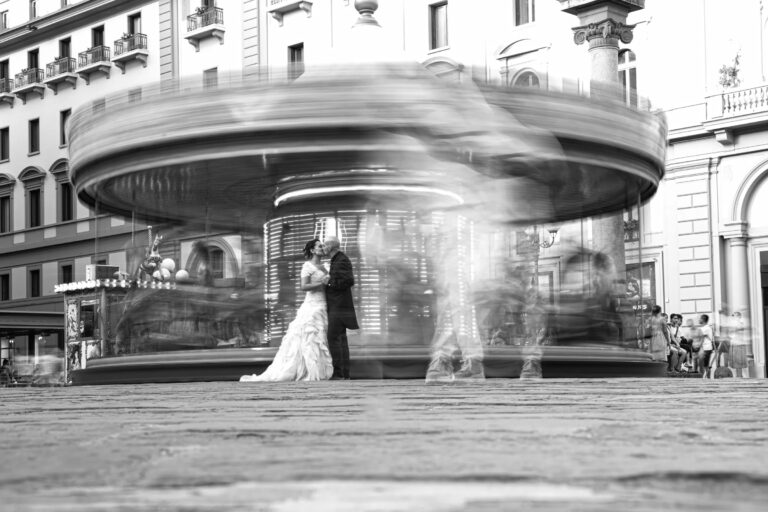 A long exposure: the couple stand still while a carousel spins around them in Florence, Simone Perini Photography