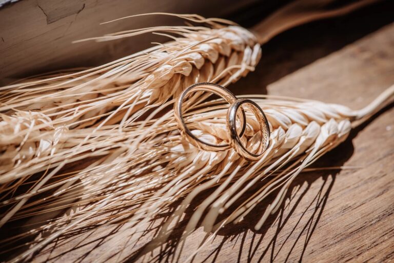 Wedding rings resting on ears of wheat, Simone Perini Photography