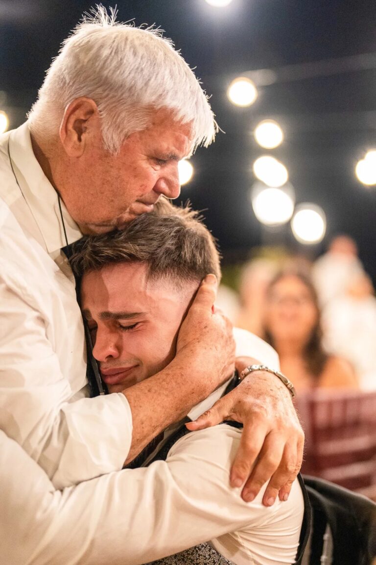 A tearful embrace under the party lights, Simone Perini Photography