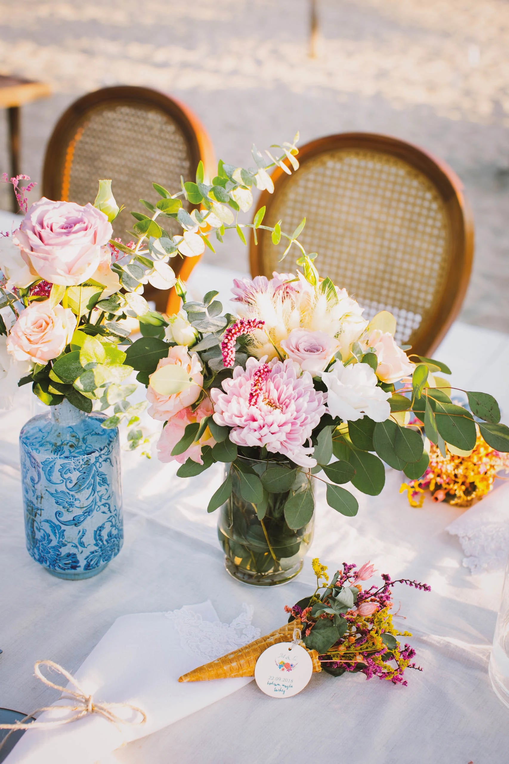 A wedding table with fresh pink and orange flowers in a blue vase, Six Senses Kaplankaya
