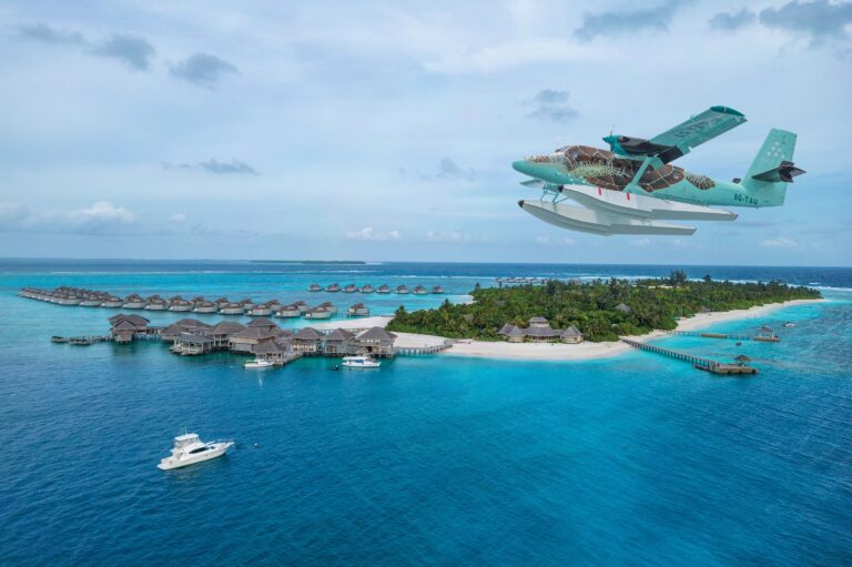 Seaplane over the lagoon beside the resort's overwater villas, Six Senses Laamu