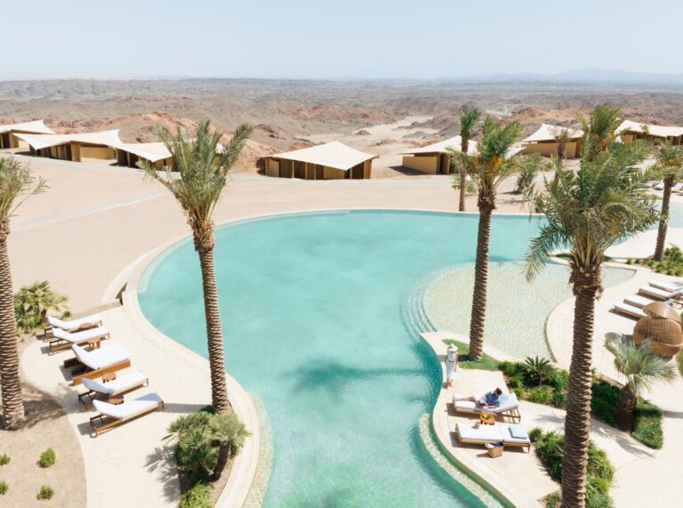 The resort pool among palms, seen from above, Six Senses Southern Dunes