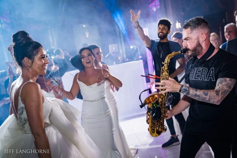 The saxophonist performs as the bride dances at a luxury wedding reception, Six15 Events