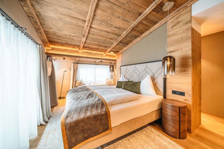 Room with carved headboard and wood panelling, Ski Hotel Maiensee