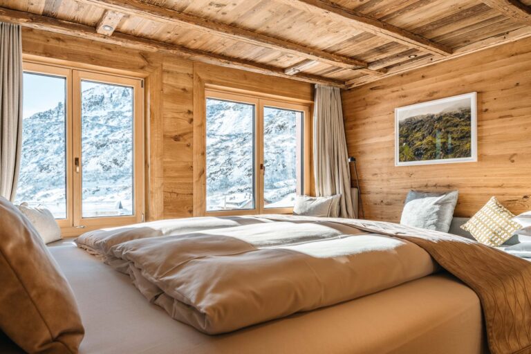 Bedroom with mountain-view windows, Ski Hotel Maiensee