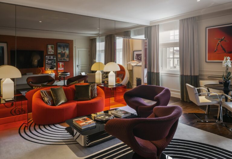 The Suite 70 lounge, furnished in orange and burgundy with mirrored walls, Sofitel London St James