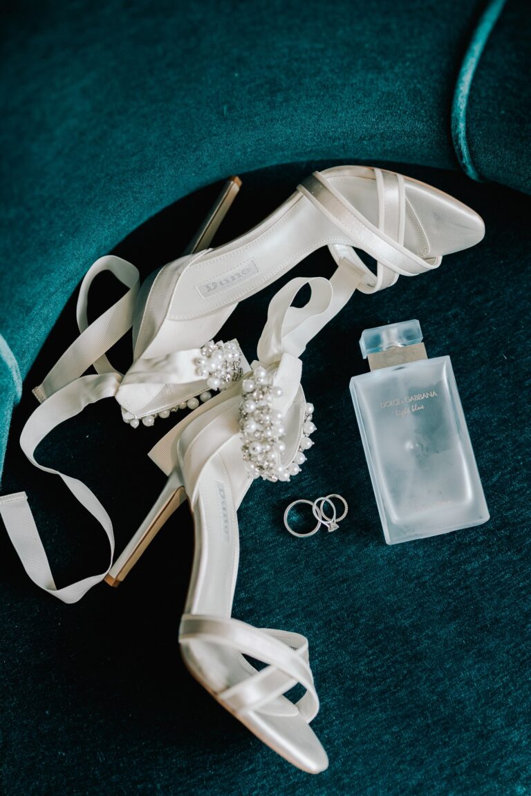 Bridal shoes, rings and perfume laid on a velvet chair, Sofitel London St James